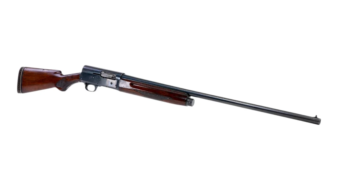 Bolt-action rifle with a wooden stock and long metal barrel on a white background