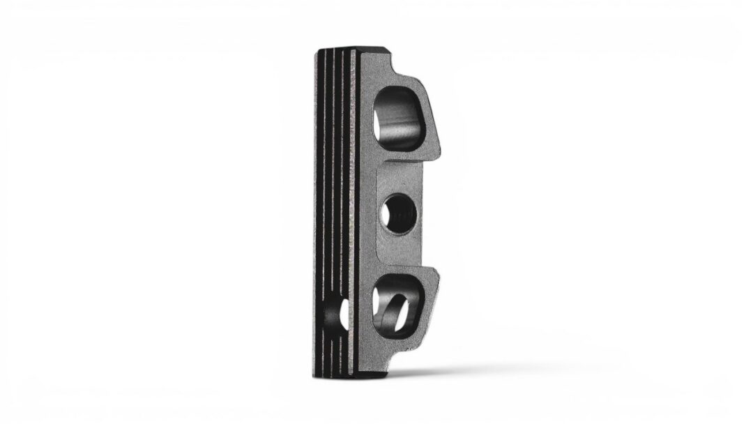 Metal mounting bracket with two circular holes and a slotted top, standing upright on a white background.