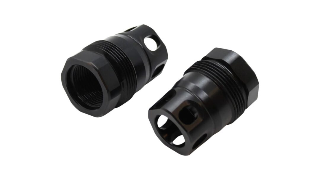 Two black metal threaded adapters with hexagonal ends laid on a white background