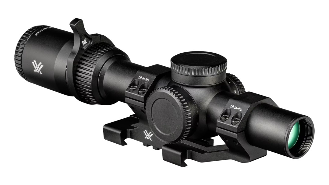 Black riflescope with magnification adjustment and mounting rail, angled to show objective lens and adjustment knobs