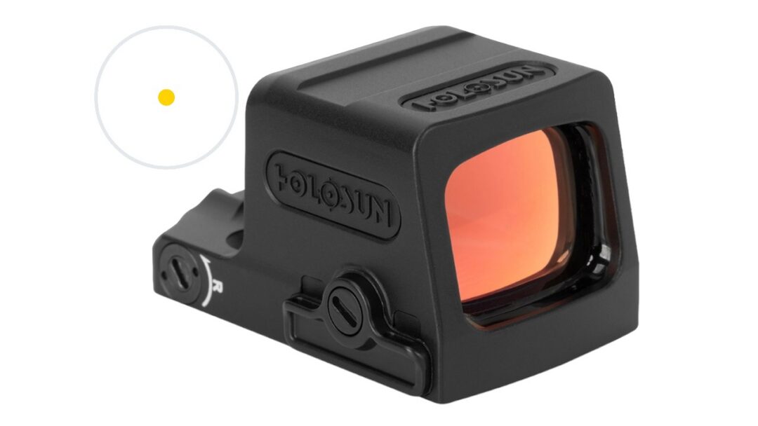 Close-up of a black Holosun red dot reflex sight with an amber-tinted front lens attached to a rail system
