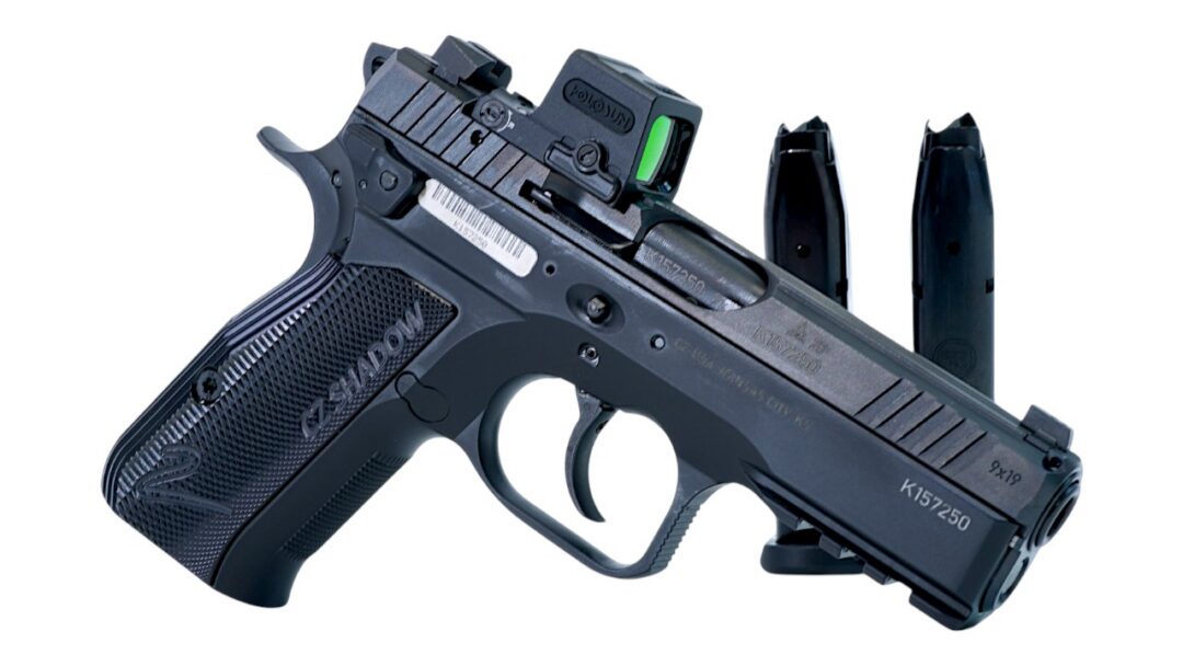 Compact semi-automatic pistol with a mounted sight and two magazines behind it
