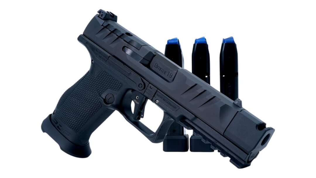 Black semi-automatic pistol with a textured grip and three magazines in the background.