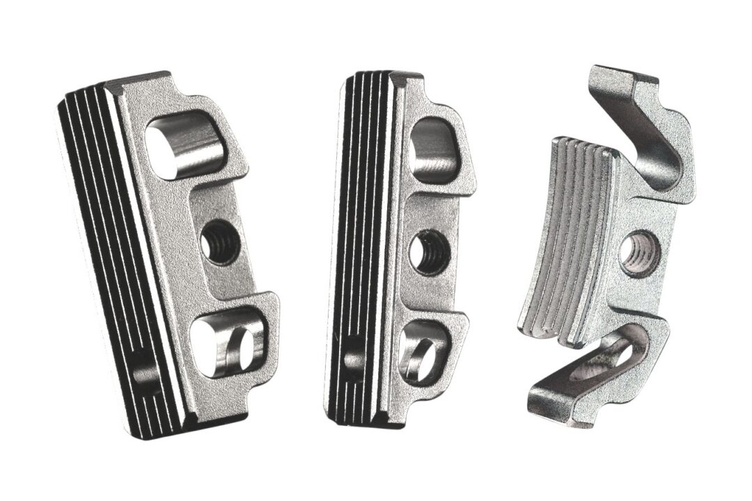 Three silver metal clamps with grooves and screw holes, arranged left to right on a white background.