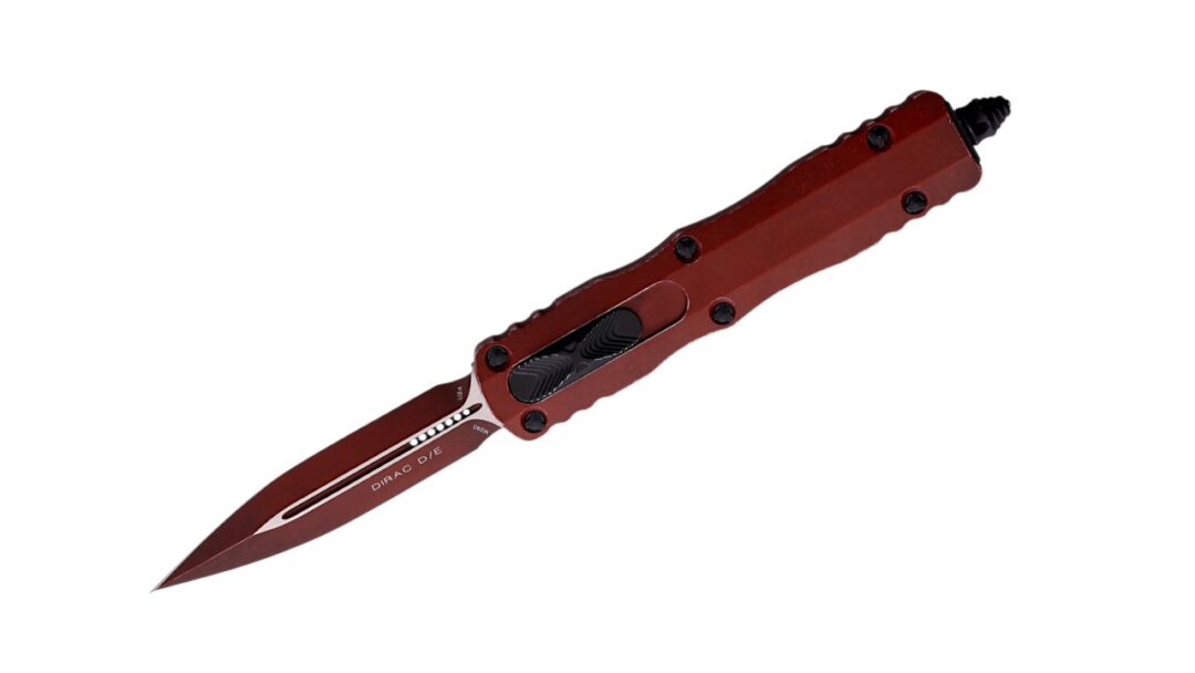 Red folding balisong knife with black grips, blade extended against white background